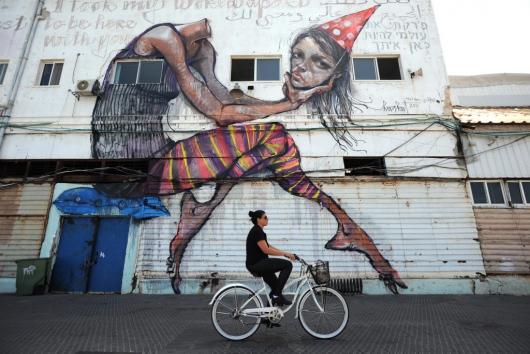 A woman rides her bicycle in Old Jaffa Port, Tel Aviv, Israel.